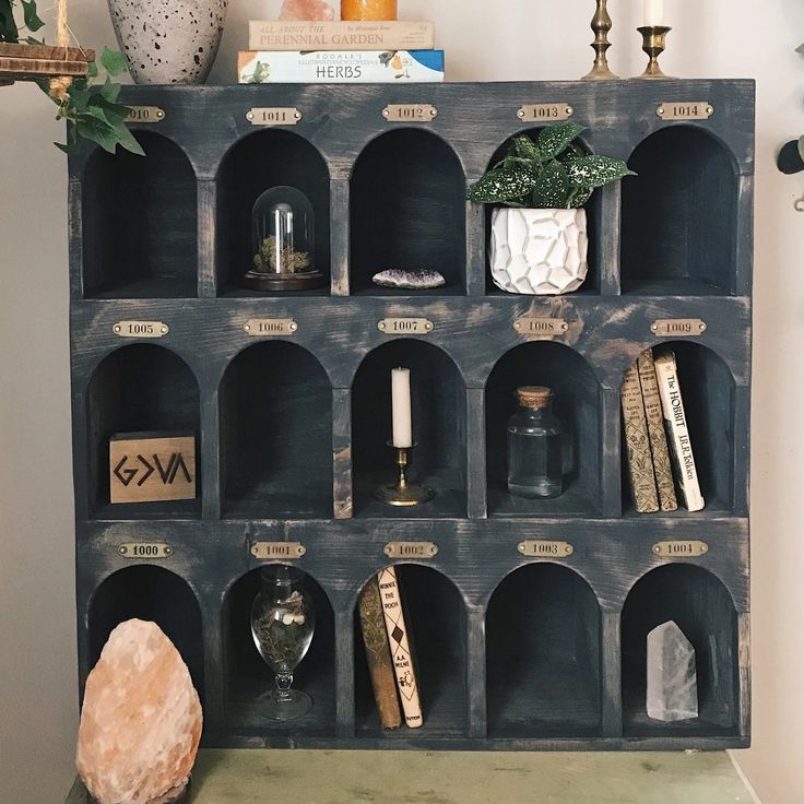 a shelf filled with books and candles on top of a table