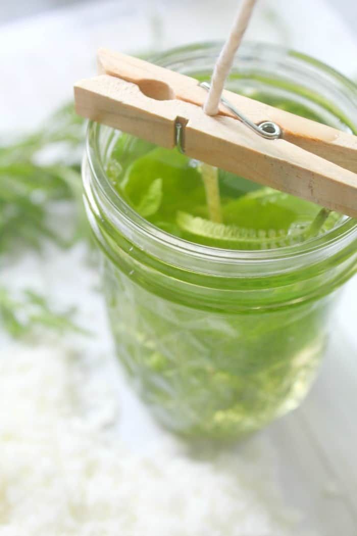 a mason jar filled with green liquid and wooden skewers sticking out of it