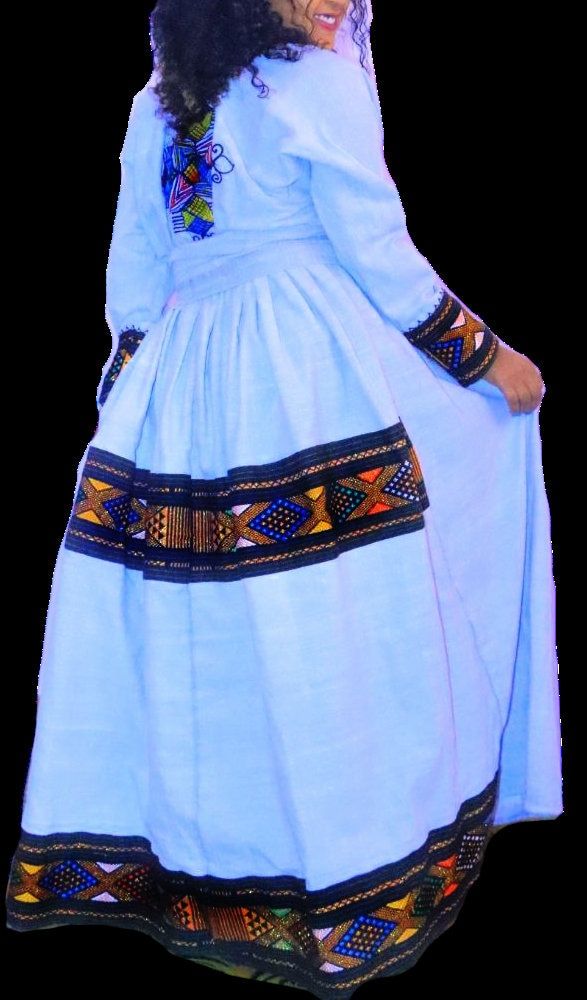 "This is a beautiful Ethiopian traditional dress from the area of Wollo/Raya. It is made by hand from 100% organic cotton. It features a beautiful \"tilet\" design (embroidery) full of beautiful colors and shiny gold threads. It comes with a \"netela\" (headscarf) and \"mekenet\" (waist scarf)." Folk Style Fitted Dress With Woven Motifs, Fitted Cotton Dresses With Traditional Patterns, Folk Style Cotton Dress With Traditional Patterns, Cotton Dresses With Multicolor Embroidery For Traditional Ceremonies, Cotton Dress With Embroidered Border For Traditional Ceremonies, Traditional Cotton Embroidered Dress With Traditional Patterns, Traditional Cotton Embroidered Dress, Traditional Embroidered Cotton Dress, Traditional Cotton Dress With Multicolor Embroidery