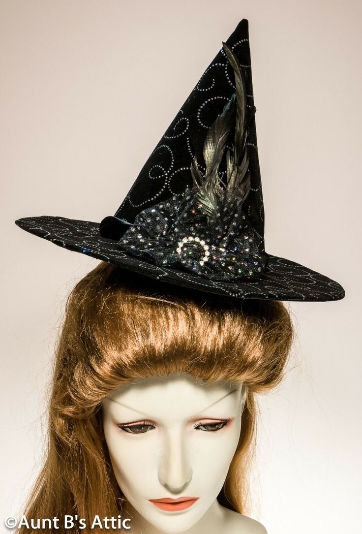 Adorable mini witch hat in rich black velvet, with a glitter swirled patterned design throughout. Black satin band, trimmed with black feathers, sequin netting, and a rhinestone ring. Elastic strap to hold in place. 8" tall, with a 2 1/2" brim. Lovely & Elegant. Halloween Wide Brim Fitted Mini Hat, Fitted Wide Brim Mini Hat For Halloween, Fitted Witchy Hat For Halloween, Halloween Fitted Wide Brim Costume Hat, Fitted Brimmed Halloween Hat, Fitted Wide Brim Halloween Costume Hat, Fitted Brimmed Hat For Halloween, Halloween Costume Cap, Novelty Brimmed Halloween Costume Hats And Headpieces