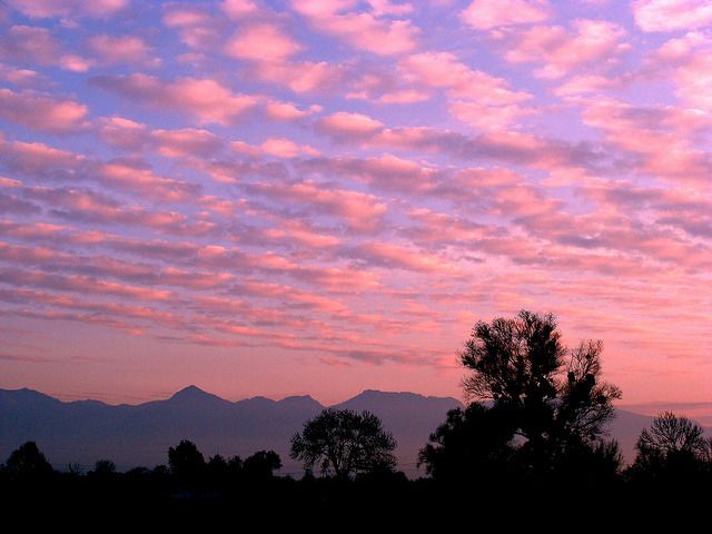 the sky is pink and purple with some clouds