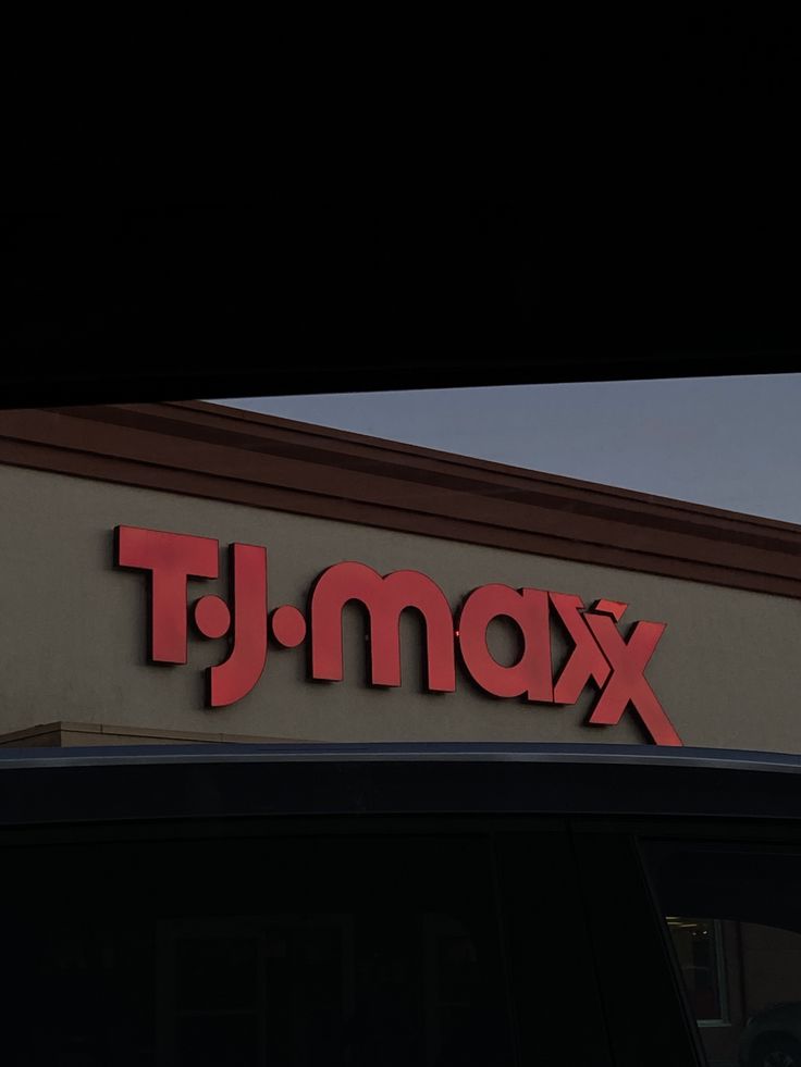 a tj max store sign is shown on the roof of a car in front of a building