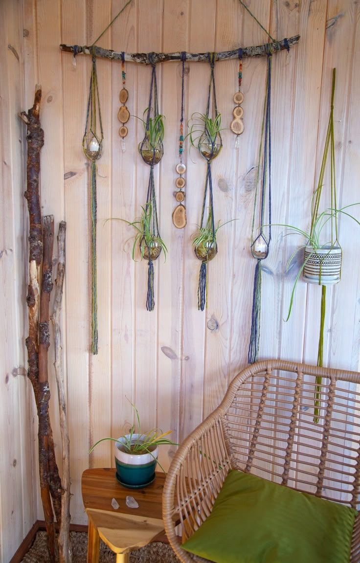 a chair and table with plants hanging from the wall