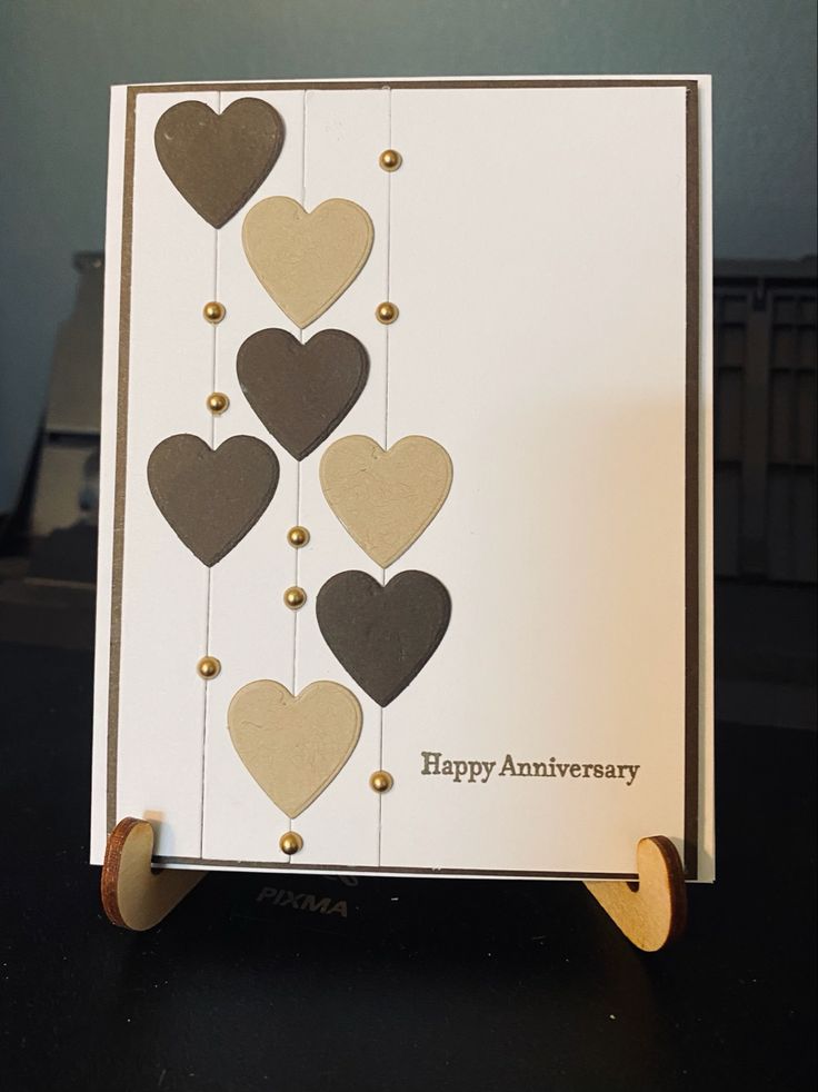 an anniversary card with hearts hanging from it's sides and the words happy anniversary