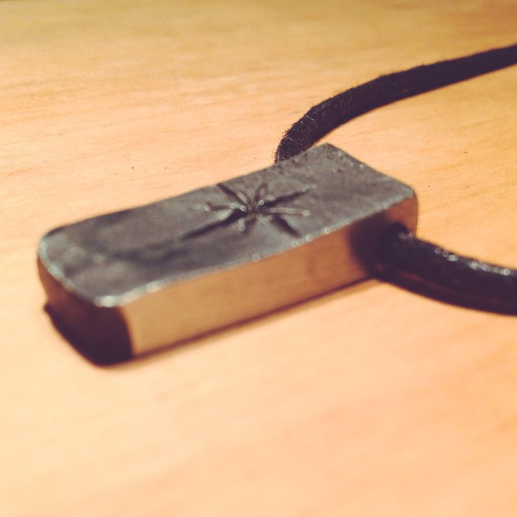 a metal object on a wooden table with a black cord attached to the end of it