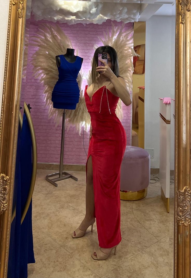 a woman taking a selfie in front of a mirror with an angel wings on it