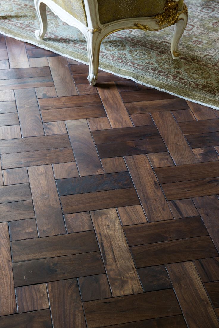 a wooden floor with a chair and rug in the background