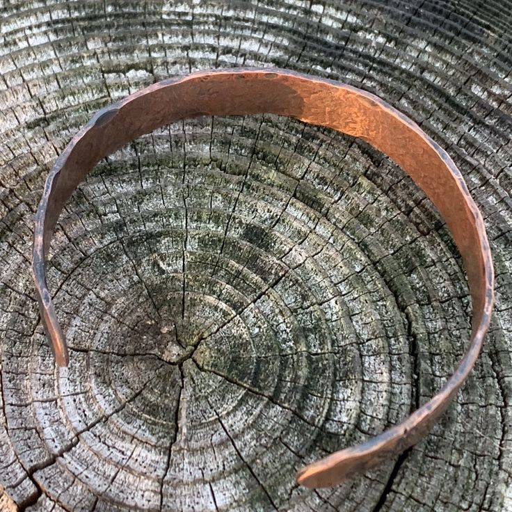 A rustic handmade bracelet that celebrates the beauty of nature and the majesty of the forest with the mountains, trees and deer hand stamped around the rustic copper cuff. Perfect for the hunter or hiker in your life. This engraved copper bracelet is hand forged and finished with a hammered finish to give it a rustic look, perfect for men and women alike. Each bracelet is handmade, and no two will be exactly alike. Also please be aware that colors may vary due to viewing screens. If you have an Bronze Copper Cuff Bracelet For Gift, Engraved Copper Bracelet Jewelry, Copper Cuff Bracelet Wearable Art Gift, When Someone Leaves You, Deer Bracelet, Elegant Silver-colored Copper Cuff Bracelet, Artisan Silver-colored Copper Cuff Bracelet, Copper Anniversary Gifts, Copper Anniversary