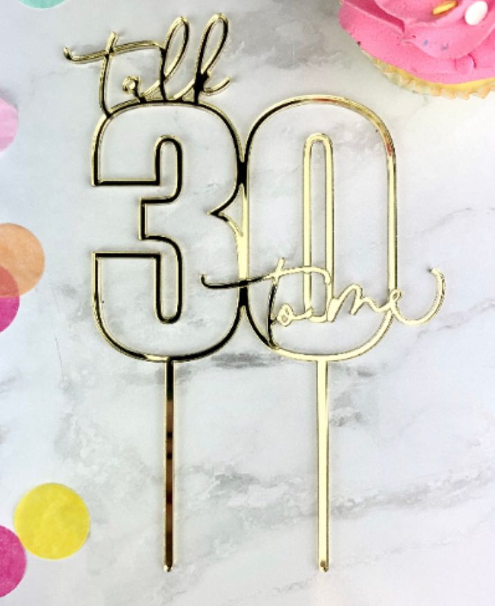 a cake topper with the number 30 on it next to some cupcakes