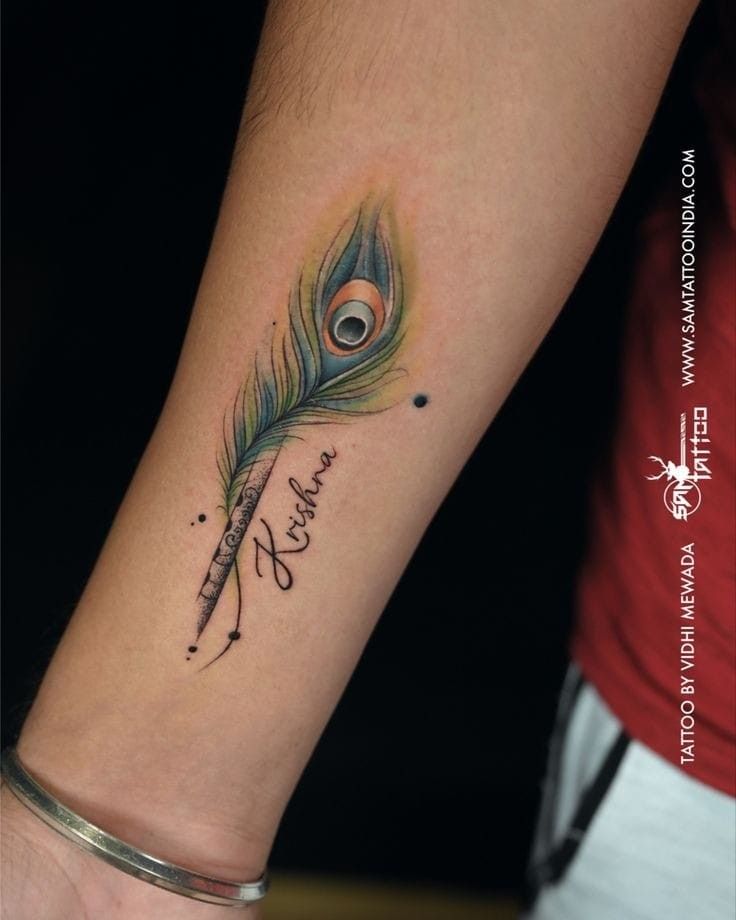 a woman's wrist with a peacock feather and name tattoo on her left arm