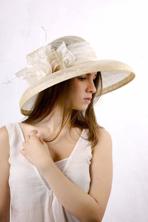 Gorgeous and chic extra wide brim sinamey hat with a astonishing decoration from ivory satin with golden dots, sinamey ribbon with golden stripes and white feathers. The wide brim make it really special and it suits almost all face types. The hat is hand blocked on a wooden block and hand stitched to perfection in Irina Sardareva millinery atelier. It is great to wear on Derby races, Cocktail parties, Weddings, Tea parties, etc.This hat is on stock  size 57 cm / 22.25''.Other sizes and colors ar Brimmed Top Hat For Wedding, Chic Formal Panama Hat With Curved Brim, Chic Beige Straw Hat For Garden Party, White Chic Boater Hat With Flat Brim, Chic White Flat Brim Boater Hat, Chic White Boater Hat With Flat Brim, Chic Beige Sun Hat For Garden Party, Elegant Adjustable Hat For Wedding, Fitted Wide Brim Boater Hat