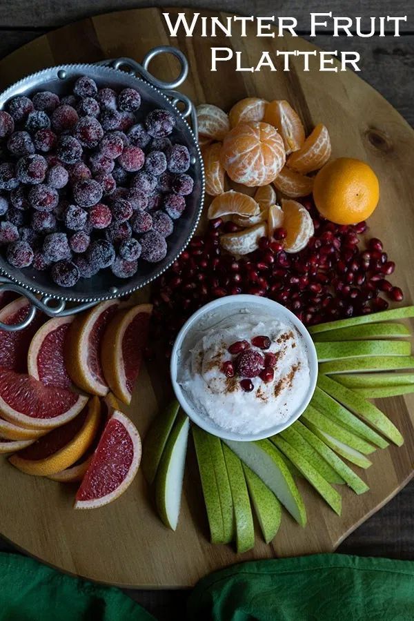 an assortment of fruits and vegetables on a wooden platter with the words winter fruit platter