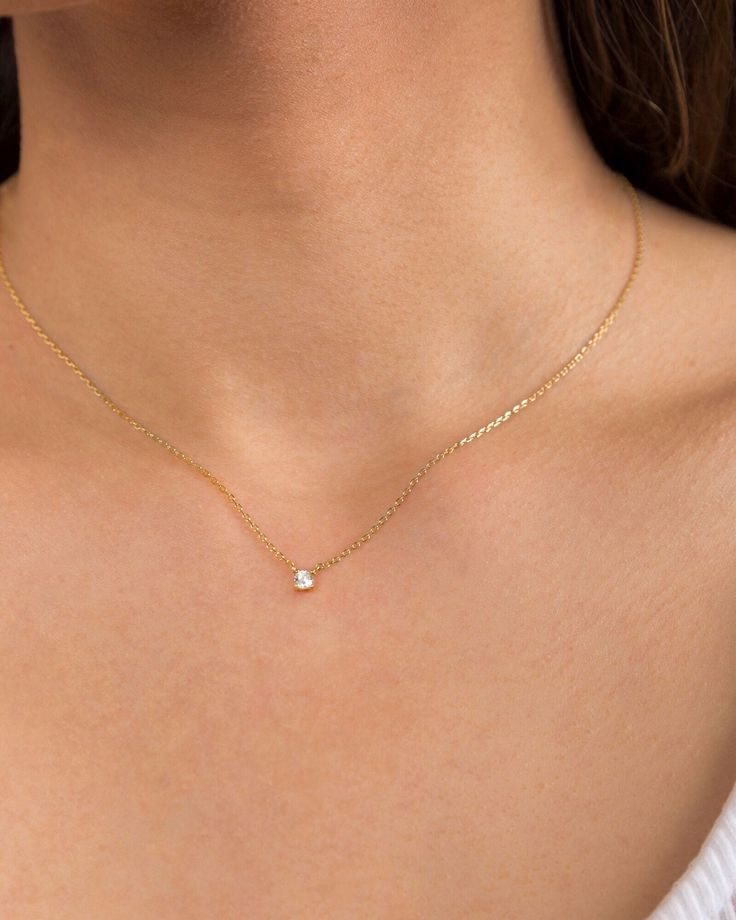 "A timeless solitaire necklace featuring a tiny brilliant cubic zirconia stone at the centre of a delicate chain. Simple and elegant, this is the perfect little something for your neck. A minimal everyday piece that layers well with other necklaces but is also perfectly dainty on its own. * Choose between 3mm or 4mm cubic zirconia stone on the dropdown menu. Model wears 3mm. * D E T A I L S * ∙ Material: .925 Sterling Silver or 18K Gold Plated over .925 Sterling Silver ∙ Stone: White Zirconia ∙ Gold Dainty Necklace, Solitaire Diamond Necklace, Solitaire Necklace, Diamond Solitaire Necklace, Dainty Gold Necklace, Solitaire Necklaces, Solitaire Diamond, Delicate Chain, Minimalist Necklace