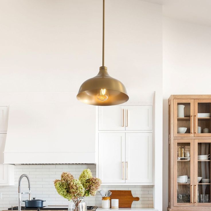 a kitchen with white cabinets and an island that has flowers on it in the center