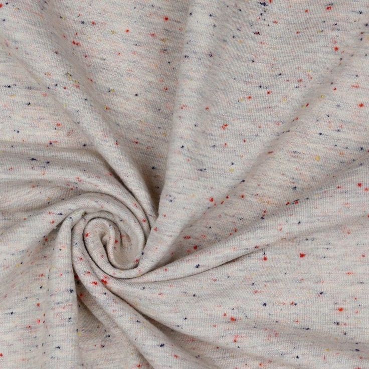 a white fabric with multicolored dots is shown in close up view on the surface