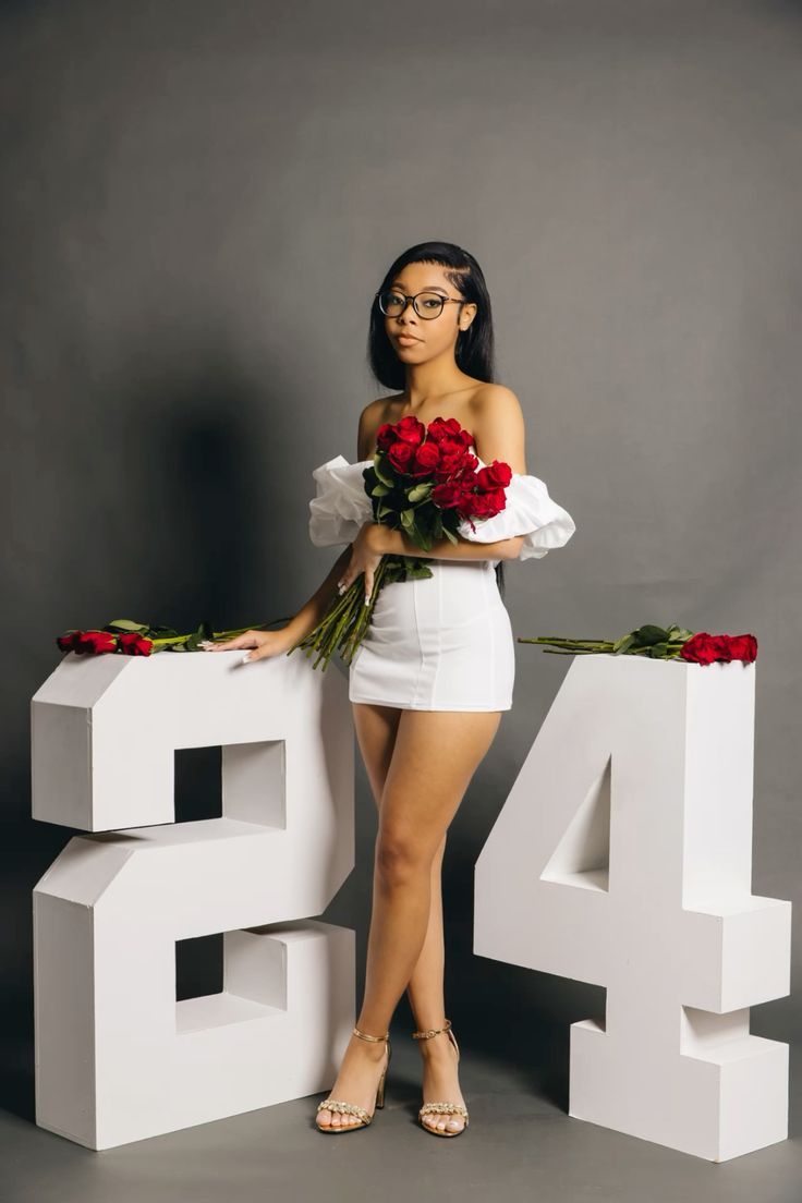 a woman is posing with flowers in front of the numbers