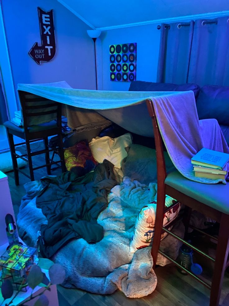 a bunk bed with lots of blankets on top of it in a room filled with furniture