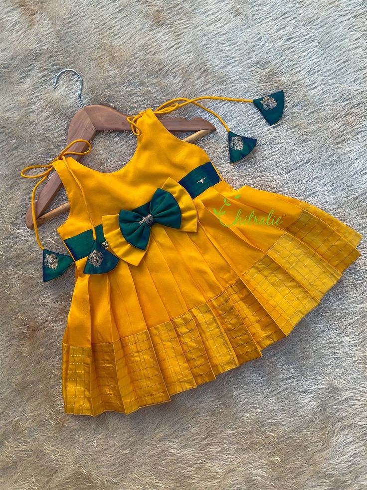 BUYER'S PLEASE LEAVE YOUR CONTACT NUMBER. It's necessary for shipping. READY TO DISPATCH Age: 0-4 Year New born yellow pure silk  knot frocks for cradle ceremony and celebrations. A contrast teal blue bow capture attention. The dress is fully lined with soft cotton and the stitches are concealed. So your little princess feels comfortable in this frock.  A man's daughter is his heart💓. Just with little feet's walking out in the world. Chitralie by Lekha Meera proudly announcing the launch of our Silk Frocks For Kids, Traditional Baby Dresses, Kids Frock, Cotton Frocks For Kids, Frocks For Kids, Cradle Ceremony, Baby Summer Dresses, Kids Ethnic Wear, Kids Dress Collection