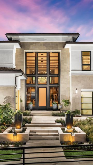 the front entrance to a modern home at dusk