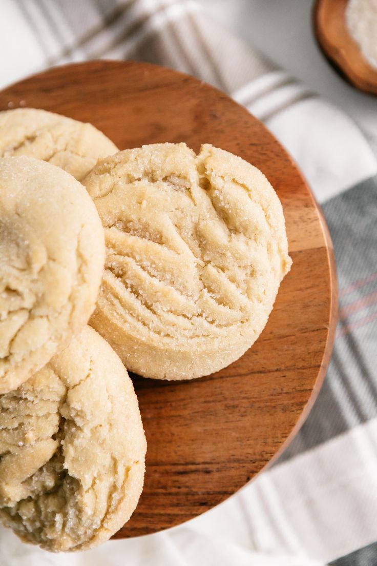 three cookies sitting on top of a wooden plate