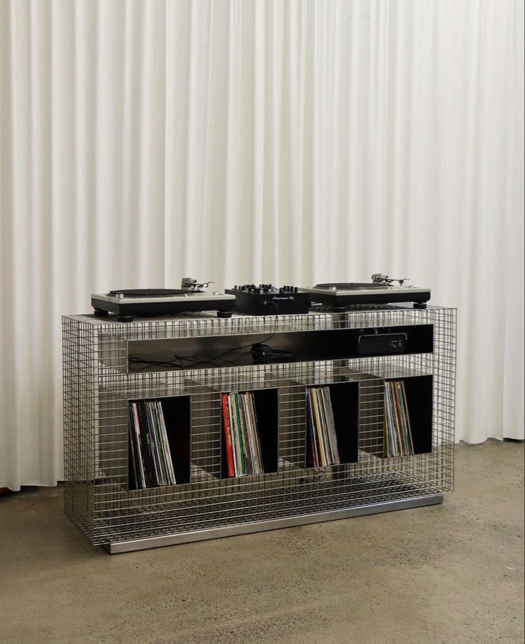 two turntables are sitting next to each other in front of a white curtain