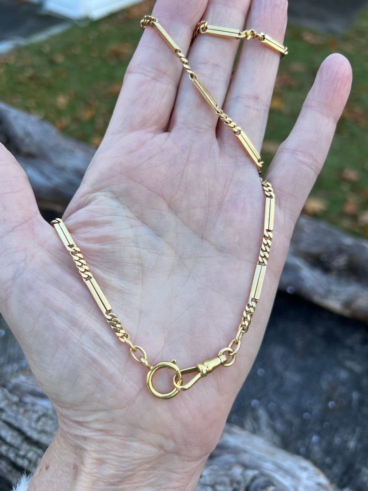 "Bewitchingly Victorian, this 18k yellow gold watch chain is alluring.  It dates from the 1800s.   The  long rectangular pieces of gold are linked together with a small chain link making for a a lavish look around your neck. Striking in an understated way.  It measures 26\" long and 1/8\".  A perfect layering chain.   It weighs 32.13 grams.  It is marked 750 (18k).   It has a truly luxurious feel to it.  N 1135 SIX MONTH LAYAWAY AVAILABLE" Timeless Formal Chain Necklace With Lobster Clasp, Timeless Gold Rectangular Necklace, Antique Jewelry With Oval Link Curb Chain, Classic Gold Chain Necklace With Hooks And Links, Victorian Link Jewelry With Curb Chain, Antique Oval Link Gold Chain Jewelry, Victorian Gold Curb Chain Jewelry, Victorian Gold Jewelry With Curb Chain, Antique Gold Jewelry With Curb Chain