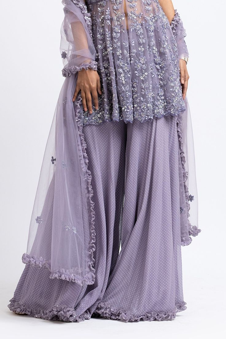 Smoky lilac peplum top with floral motifs in crystal and bead embroidery. Paired with mukaish embroidered sharara and dupatta.
Component: 3
Pattern: Embroidered
Type Of Work: Sequin, Crystal, Mukaish
Neckline: Sweetheart
Sleeve Type: Sleeveless
Fabric: Georgette, Net
Color: Purple
Other Details: 
Mukaish work
Frill dupatta
Embroidered peplum top
Occasion: Wedding - Aza Fashions Peplum Top Outfits Indian With Pants, Festive Purple Palazzo Set With Intricate Embroidery, Festive Purple Embroidered Palazzo Set, Semi-stitched Purple Palazzo Set With Intricate Embroidery, Bollywood Style Purple Palazzo Set With Intricate Embroidery, Bollywood Style Purple Embroidered Palazzo Set, Anarkali-style Purple Palazzo Set With Intricate Embroidery, Traditional Lavender Sets With Intricate Embroidery, Traditional Lavender Set With Intricate Embroidery