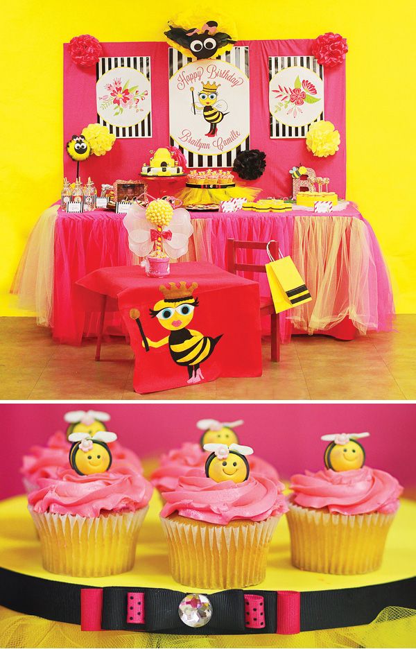 the table has cupcakes on it and decorations in pink, yellow and black