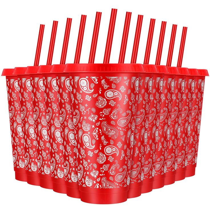 six red plastic drinking straws in a cup with paisley designs on the bottom and sides