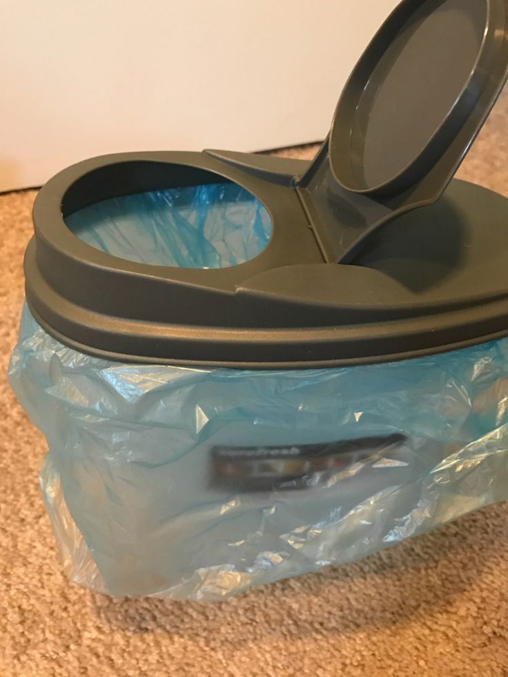 a blue plastic container with a black lid sitting on the floor