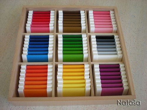 a wooden box filled with lots of different colored waxs on top of a table