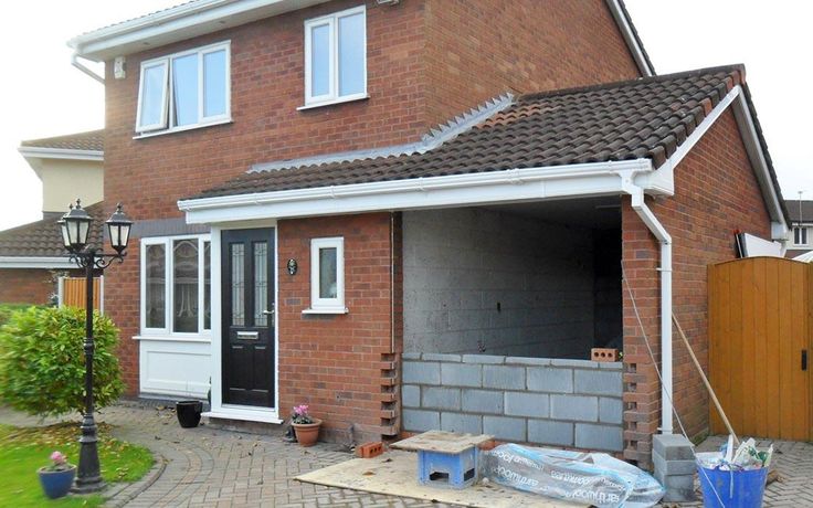 a brick house with a garage door and windows on the outside, next to a driveway