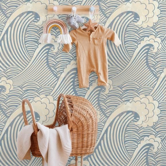 a baby's clothes hanging on the wall next to a wicker stroller