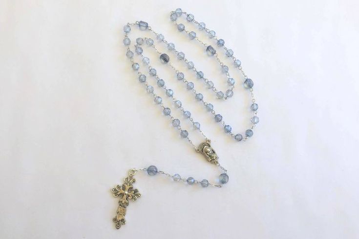 a rosary with a crucifix hanging from it's side on a white surface