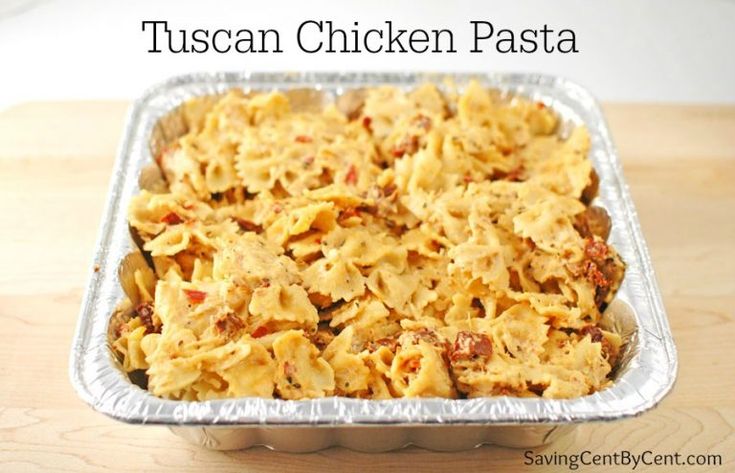 a casserole dish with pasta and meat in it on a wooden table next to a text overlay that reads tuscan chicken pasta