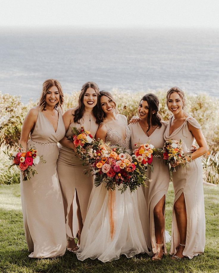 a group of women standing next to each other on top of a lush green field