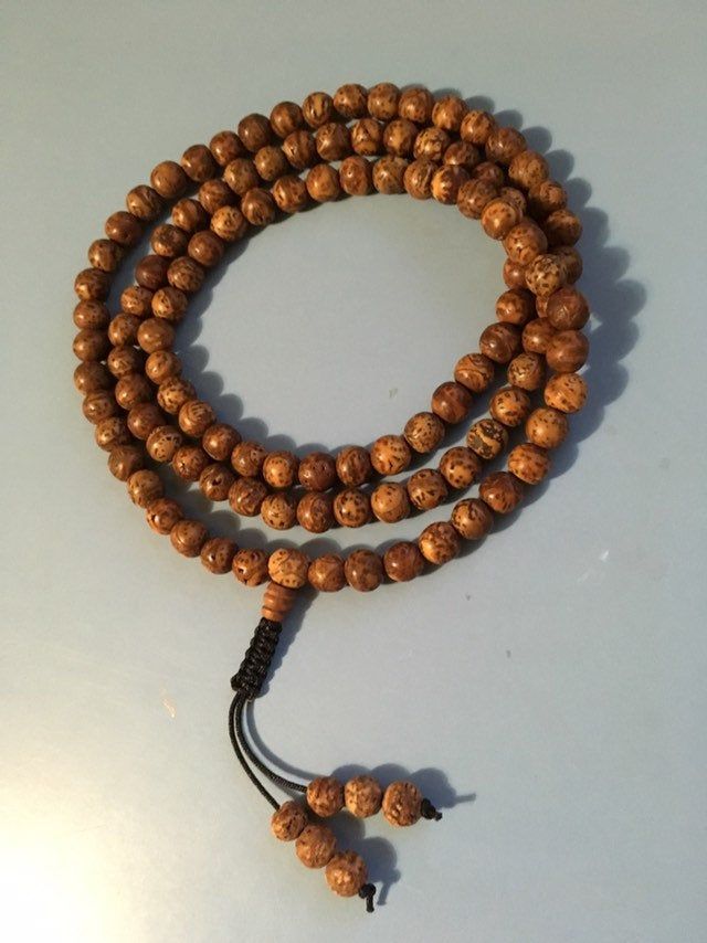 "Bodhi seed mala necklace made of 108 12mm beads with a Bodhi seed guru bead and an adjustable knot that allows you to change the length and tightness of the beads. Bodhi seeds are usually not polished so they are a solid color with small ridges or veins. Bodhi in Sanskrit translates to \"enlightened\" or \"awakened,\" therefore the Bodhi seed means \"enlightened seed.\" Bodhi is also a term in Buddhism to reflect a Buddha's understanding of the true nature of things. Many Buddhist wear the Bodh Bodhi Tree, Adjustable Knot, 108 Bead, Mala Necklace, Wrap Bracelet, Mens Bracelet, Necklace Etsy, Solid Color, Beaded Necklace