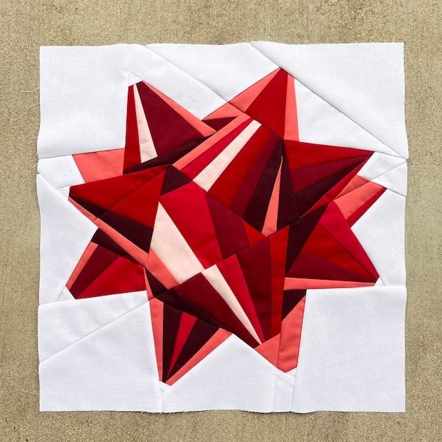 a red and white piece of art that looks like an origami star