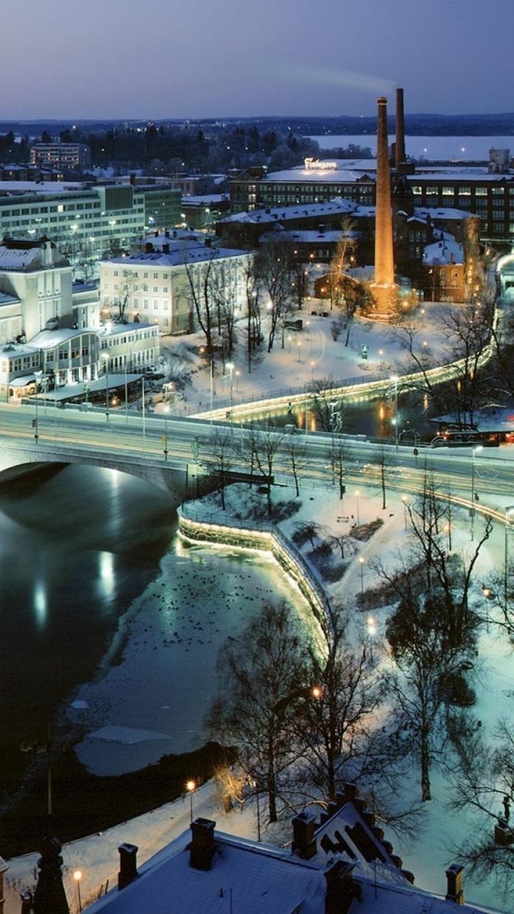 an aerial view of a city at night with snow on the ground and buildings in the background