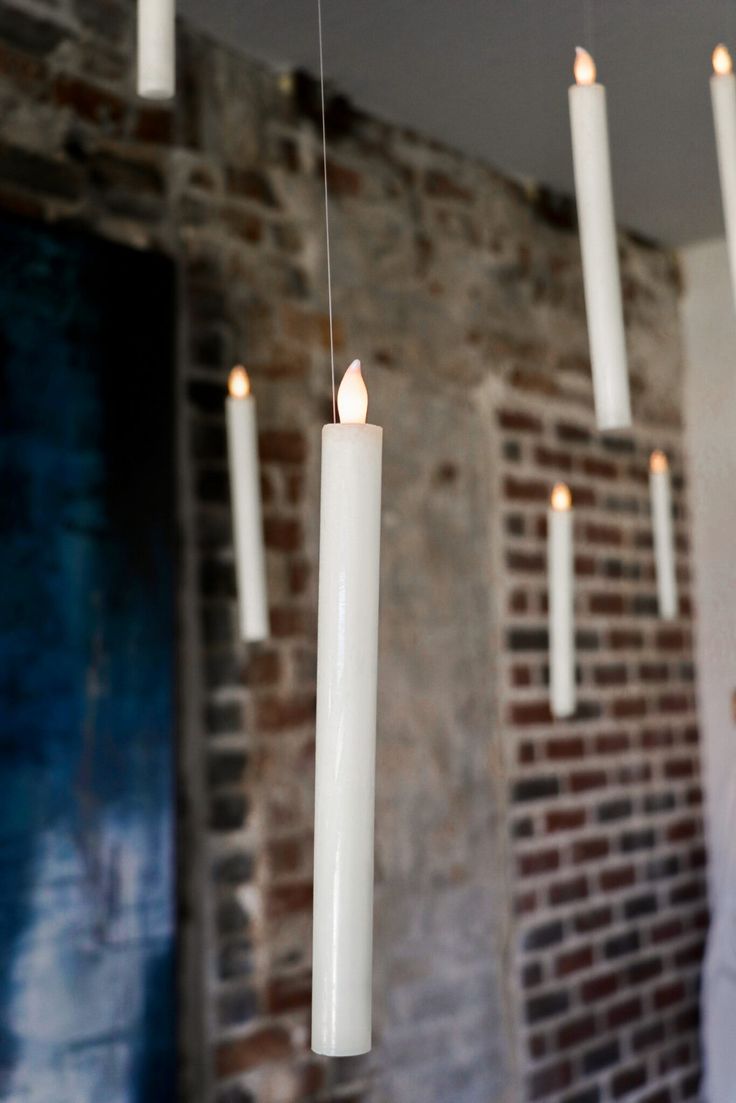 several white candles are hanging from the ceiling