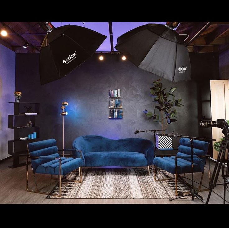 a living room with blue couches and umbrellas