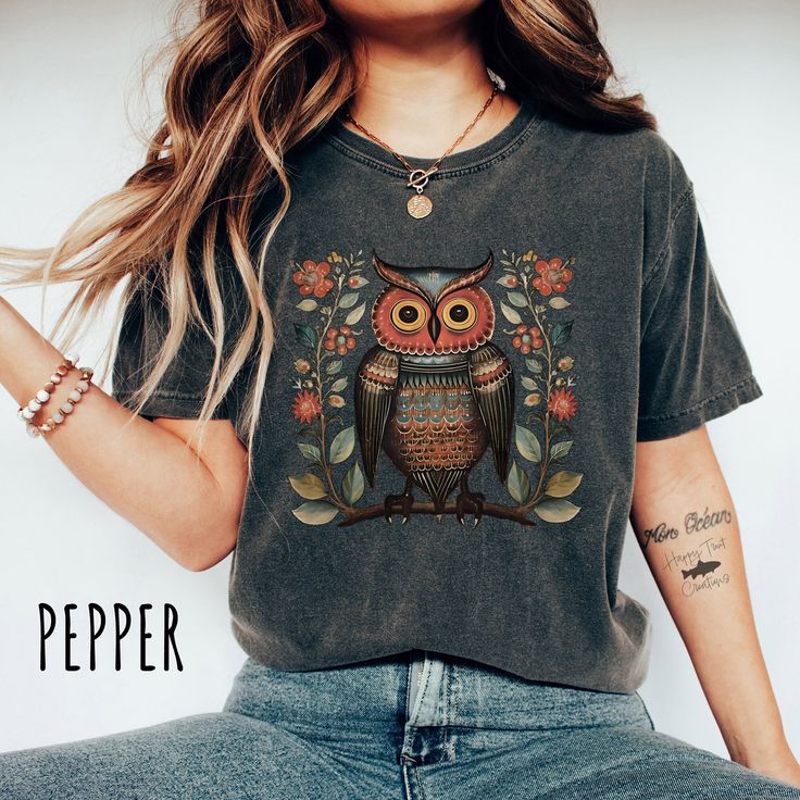 Embrace the cozy charm of boho style with our t-shirt featuring an enchanting owl surrounded by vibrant, whimsical flowers. Designed in a rich palette of colors, this cottagecore-inspired tee captures a nature-loving, free-spirited aesthetic perfect for adding a touch of bohemian magic to your wardrobe. 🐘THESE SHIRTS RUN LARGE - Please refer to the size chart before ordering 💰Exchanges and Returns accepted ™️Comfort Colors - High Quality 100% Cotton Unisex Garment-dyed Medium Weight Tees 👀Images are an accurate depiction of what you'll receive upon purchase 👣Printing is "Direct To Garment"  (Ink printed). 📏Size Chart - Please see image 🌳100% Ring-spun Cotton 🪨Mid-weight Material 🚻Unisex Sizing - Relaxed Fit 📦Free Shipping in the US 💦Machine-wash cold inside out.  Tumble dry low ? Fall Bohemian Printed Shirt, Multicolor Bohemian Relaxed Fit T-shirt, Bohemian Printed Fall Shirt, Bohemian Printed Shirt For Fall, Bohemian Printed Short Sleeve Tops, Bohemian Fall Festival T-shirt, Bohemian Style T-shirt For Fall Festival, Bohemian Boho Print Short Sleeve Top, Casual Fall T-shirt With Vintage Print