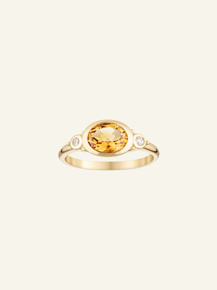 The Solid Gold Citrine and Diamond Ring features an oval Citrine stone, with two circle diamonds on either side. Item Details: 9k and 14k Solid Gold Available in five sizes Made to order PLEASE NOTE: Our current timeframe for handcrafting this Solid Gold ring is approximately 6 weeks before dispatch. Please email us at contact@loveisabelle.com for specific timeframe enquiries. Luxury Oval Yellow Sapphire Diamond Ring, Oval Yellow Sapphire Diamond Ring Fine Jewelry, Yellow Sapphire Oval Diamond Ring, Classic Yellow Sapphire Oval Rings, Yellow Gold Three-stone Oval Birthstone Ring, Yellow Gold Three Stone Oval Birthstone Ring, Yellow Sapphire Oval Ring In Fine Jewelry Style, Yellow Gold Citrine Oval Diamond Ring, Oval Citrine Diamond Ring In Yellow Gold