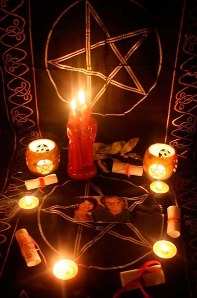 candles are arranged in the shape of a pentagram with pictures on it and other items around them