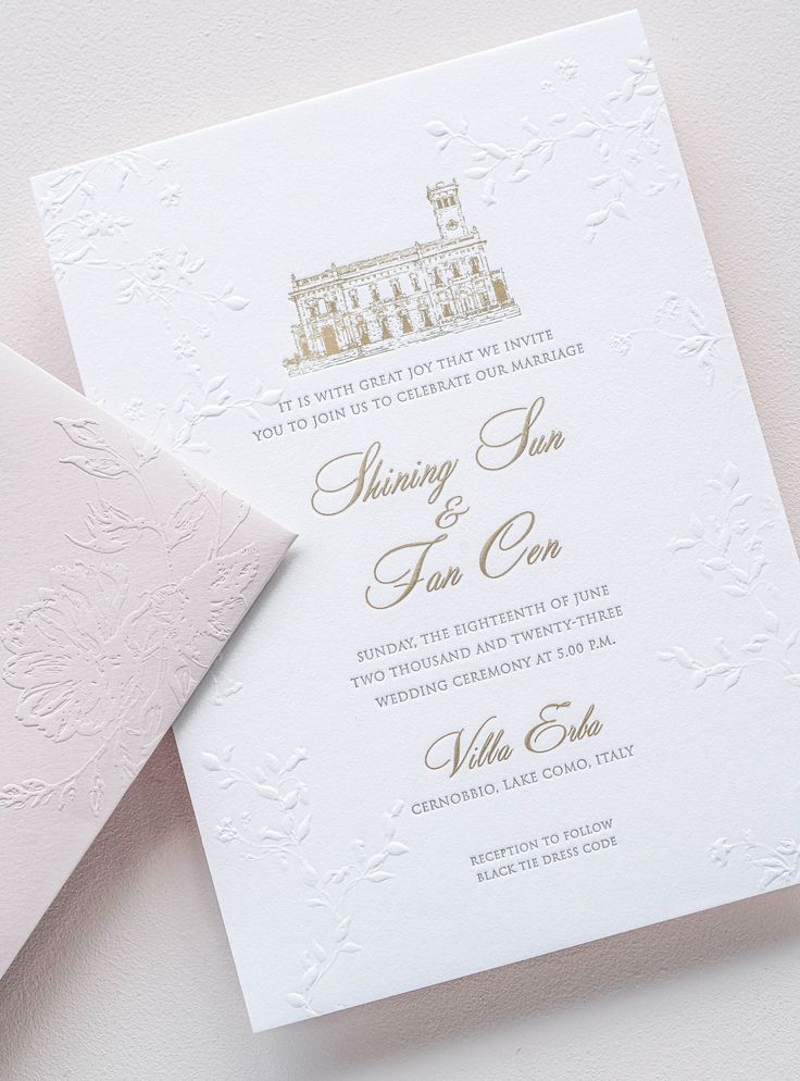 an elegant wedding card with gold foil on the front and back, sitting next to a white envelope