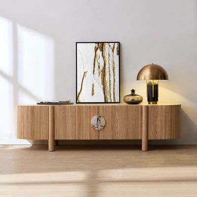 a wooden table with a clock on it next to a painting and lamp in a room