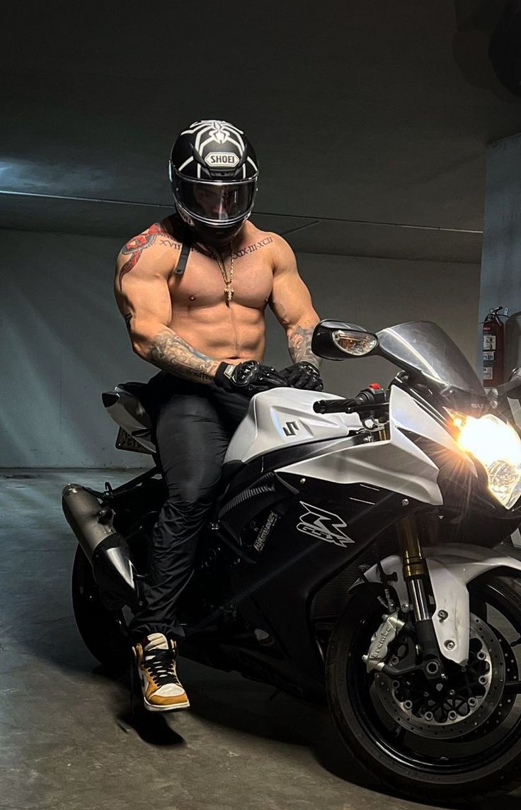 a shirtless man sitting on top of a motorcycle