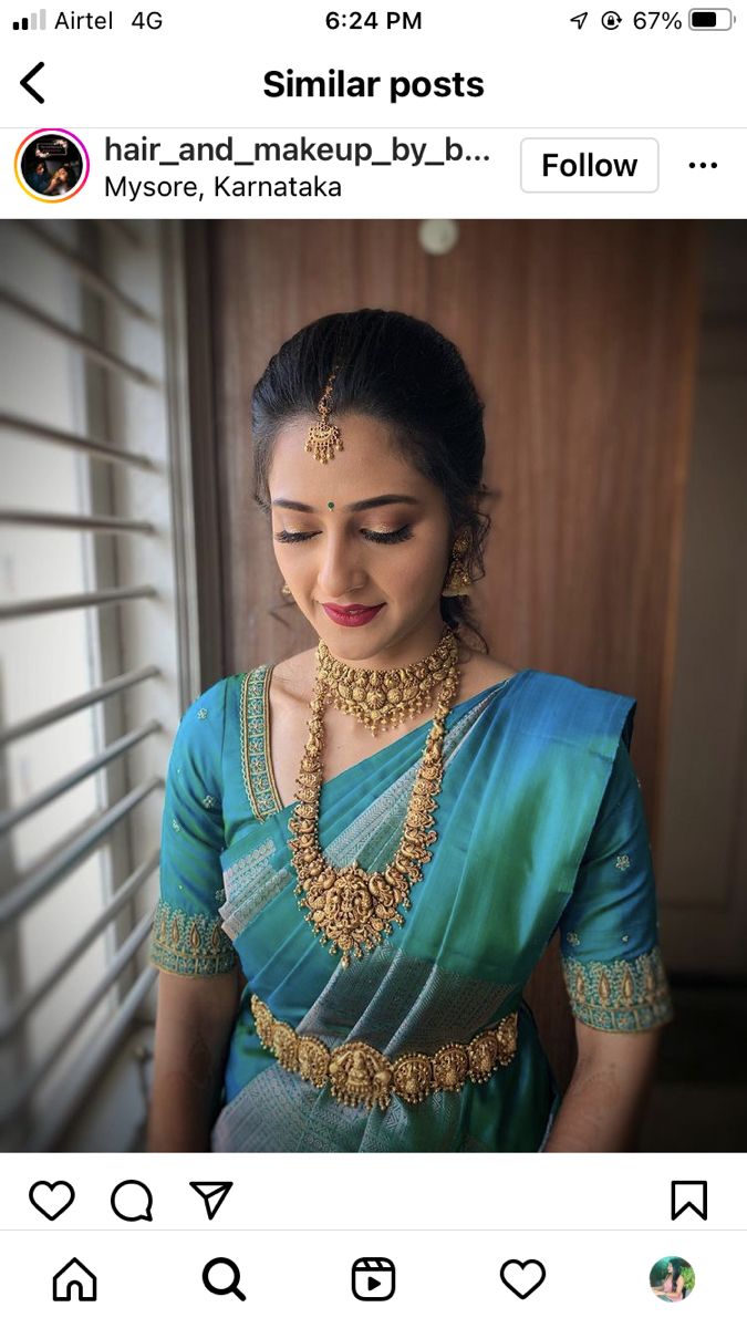 a woman in a green and blue sari with gold jewelry on her neck, looking at the camera