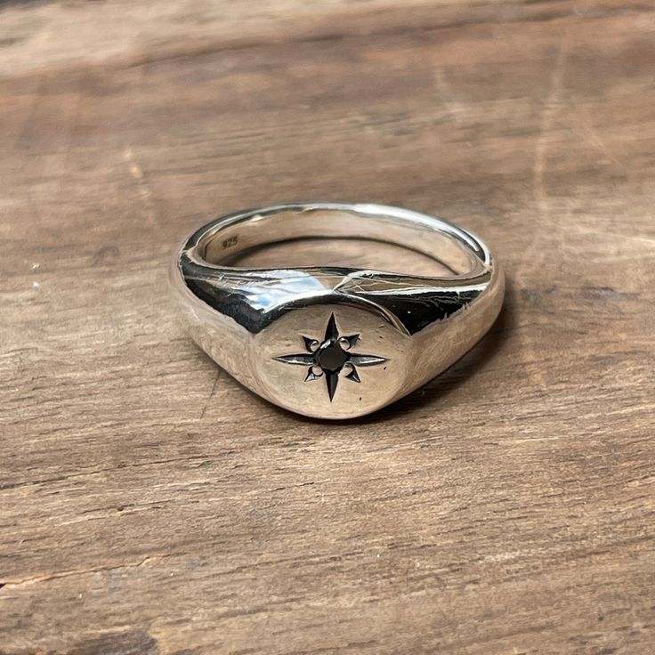 A classic small circle signet ring star-set with a 2mm black diamond. These timeless signet rings are meticulously crafted by hand in our Melbourne workshop, created out of wax and then cast into solid precious metal. Made with the highest quality Australian sterling silver to last forever. Made solid, not hollow like many others, all of our rings are hand-stamped with a Sterling Silver (925) hallmark and Custom Creed makers mark and come gift-wrapped in a branded box with satin black ribbon. Du Mens Rings Signet, Signet Rings Men, Silver Signet Ring With Single Diamond As Gift, Classic Sterling Silver Signet Ring With Single Diamond, Silver Signet Ring With Single Diamond For Gift, Star Shaped Signet Ring With Polished Finish, Silver Signet Ring With Single Diamond For Promise, Oval Silver Signet Ring For Promise, Hand Forged Sterling Silver Signet Ring For Anniversary