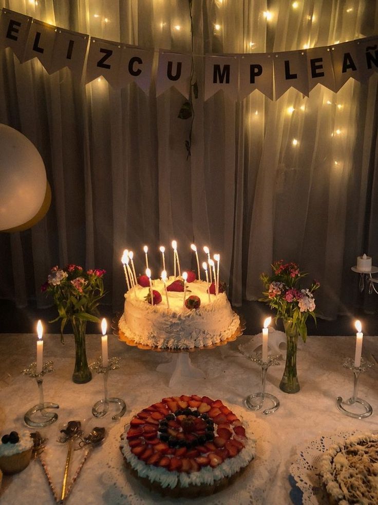 a table topped with a cake and lots of candles